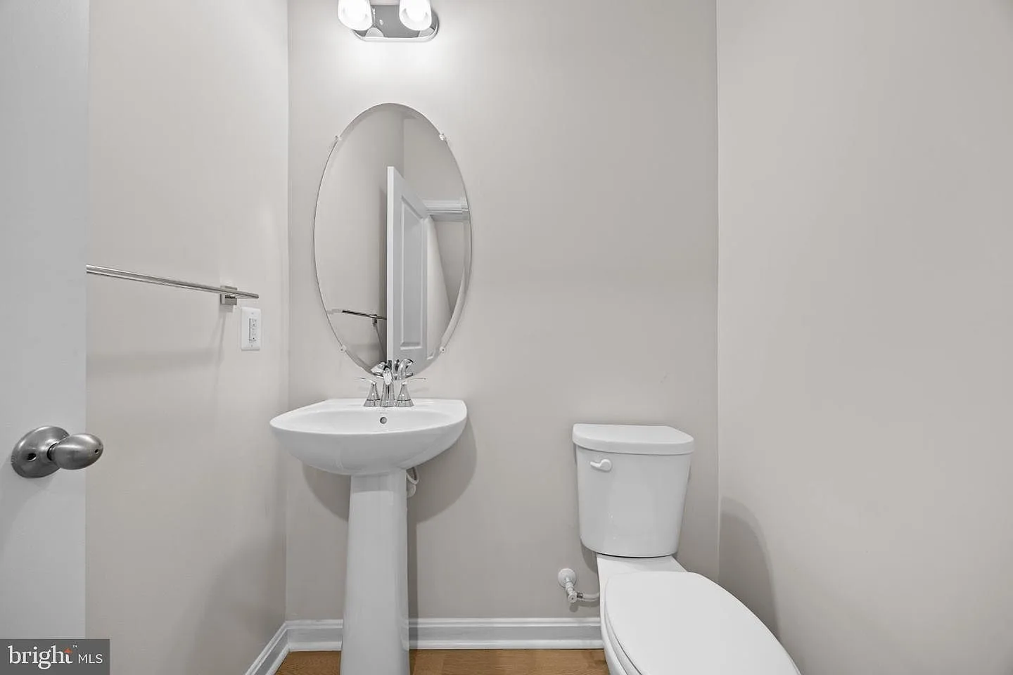 Powder room with pedestal sink and oval mirror