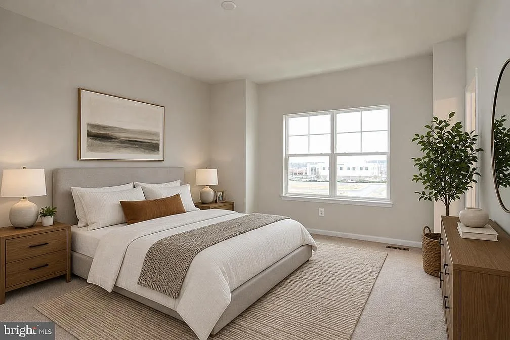 Primary suite with upholstered headboard and natural light