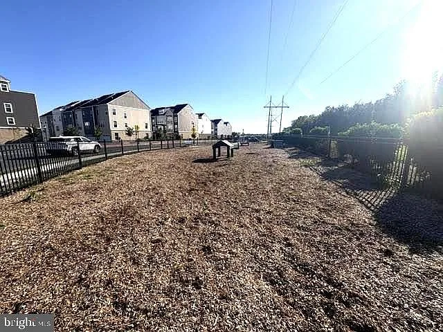 Community dog park with wood chip surface and agility structure