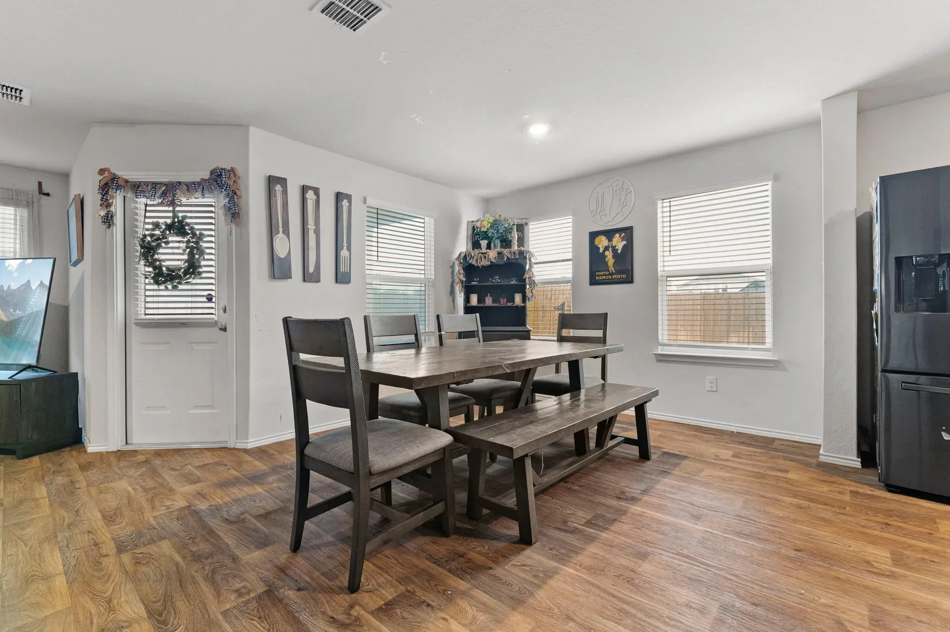 Dining room with wood-look flooring and natural light from windows