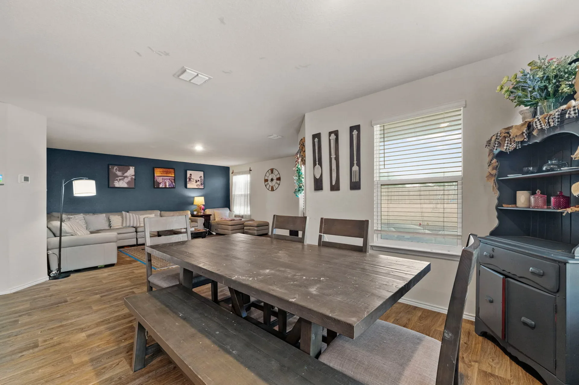 Open-concept dining room looking toward the living area with an accent wall