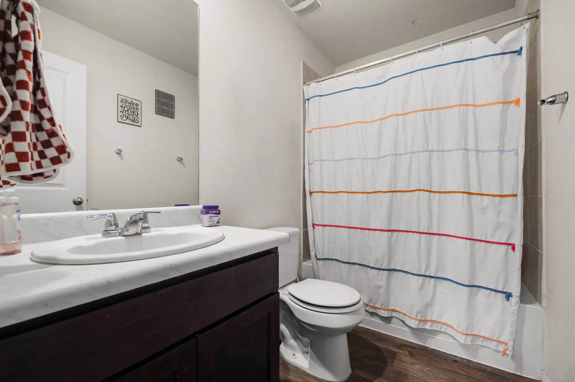 Full bathroom with dark wood vanity and white countertop