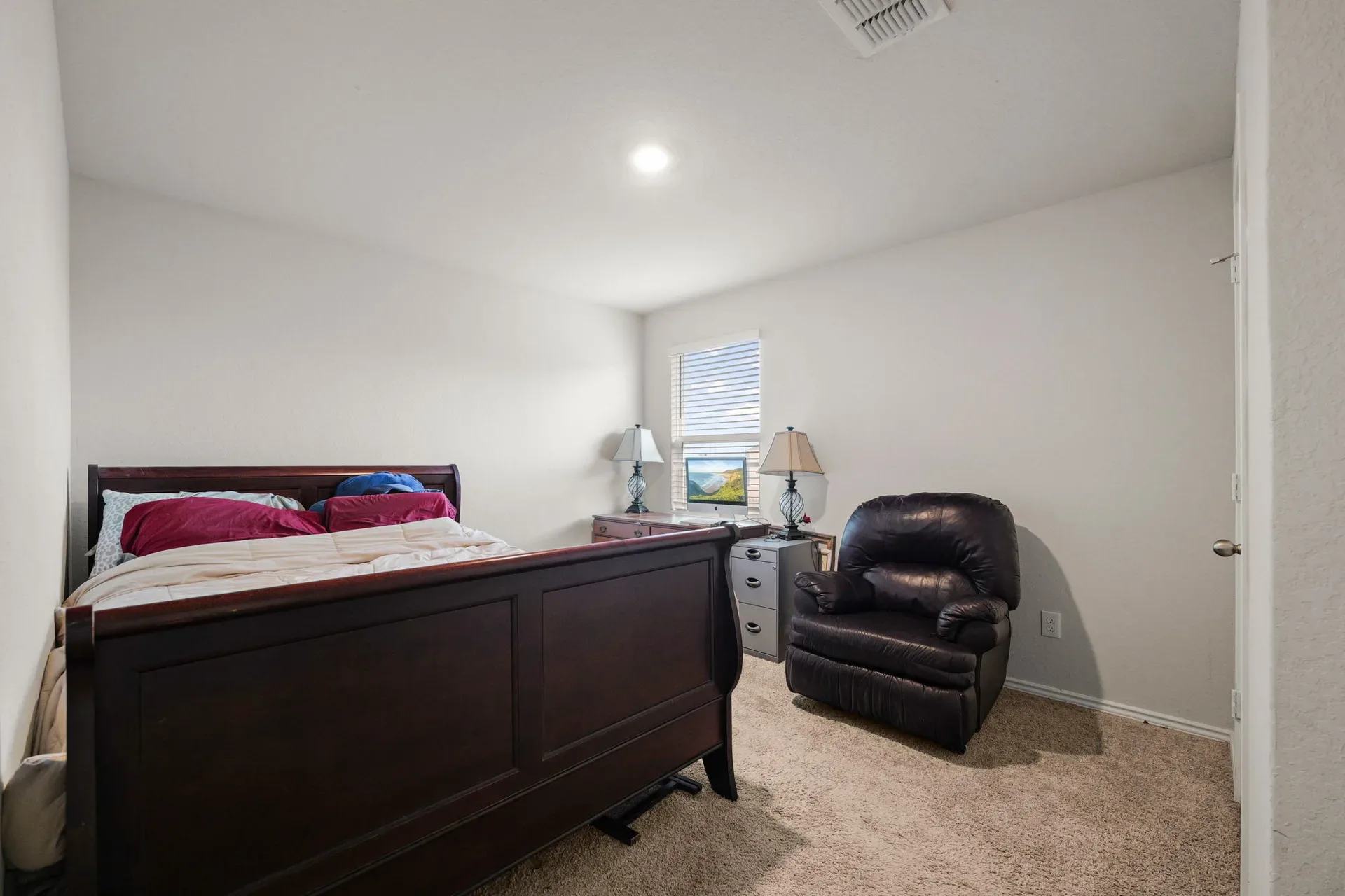 Spacious secondary bedroom with neutral beige walls and carpet