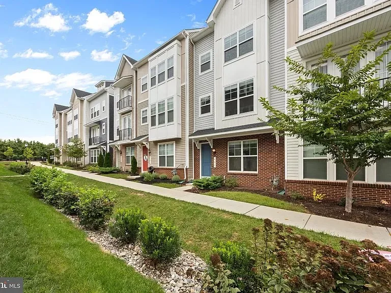 Street-level view of the townhome with landscaped front beds