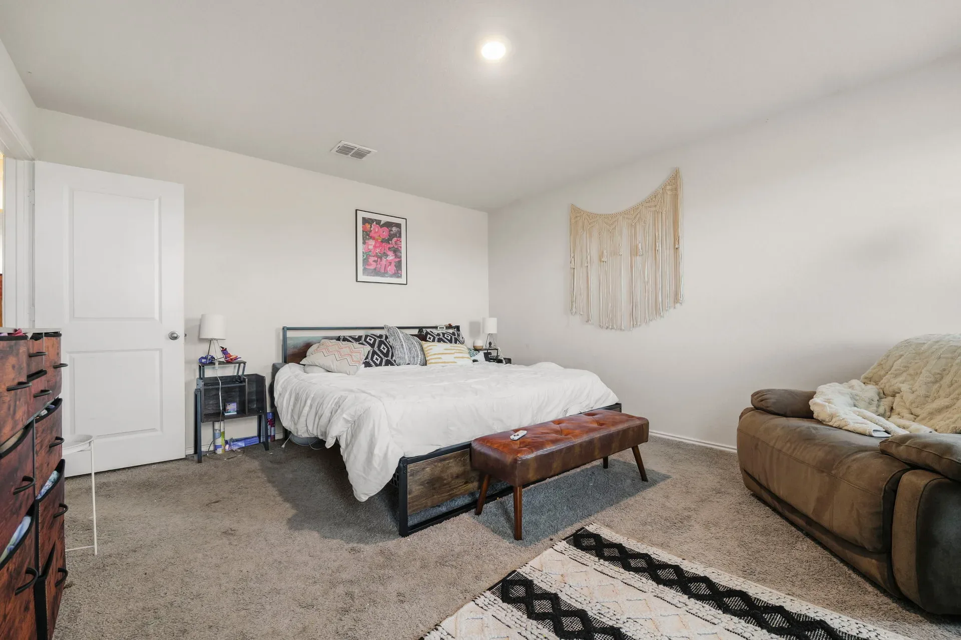 Primary bedroom with natural daylight and a calm neutral palette