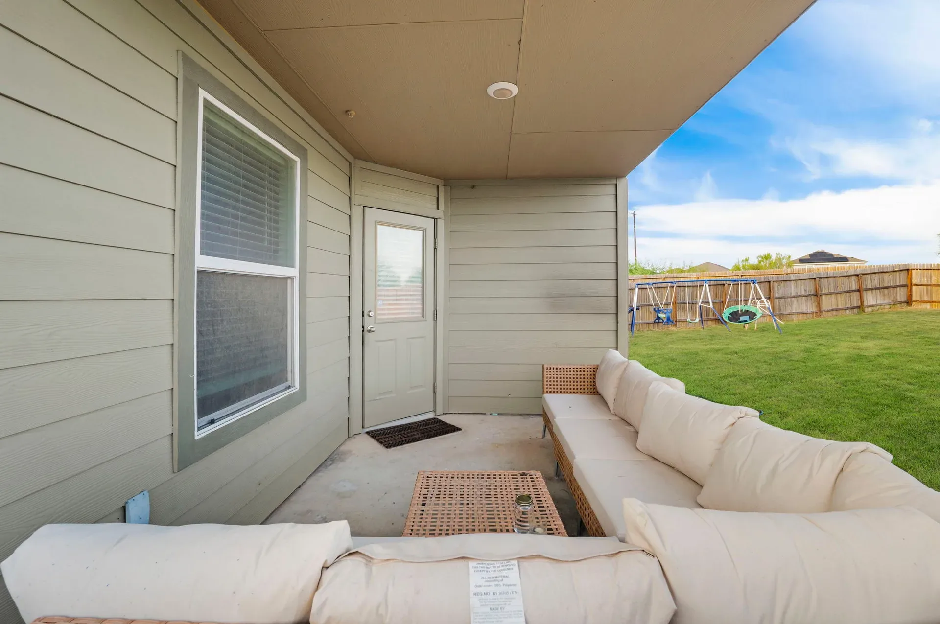 Covered back patio with concrete flooring off the rear of the home
