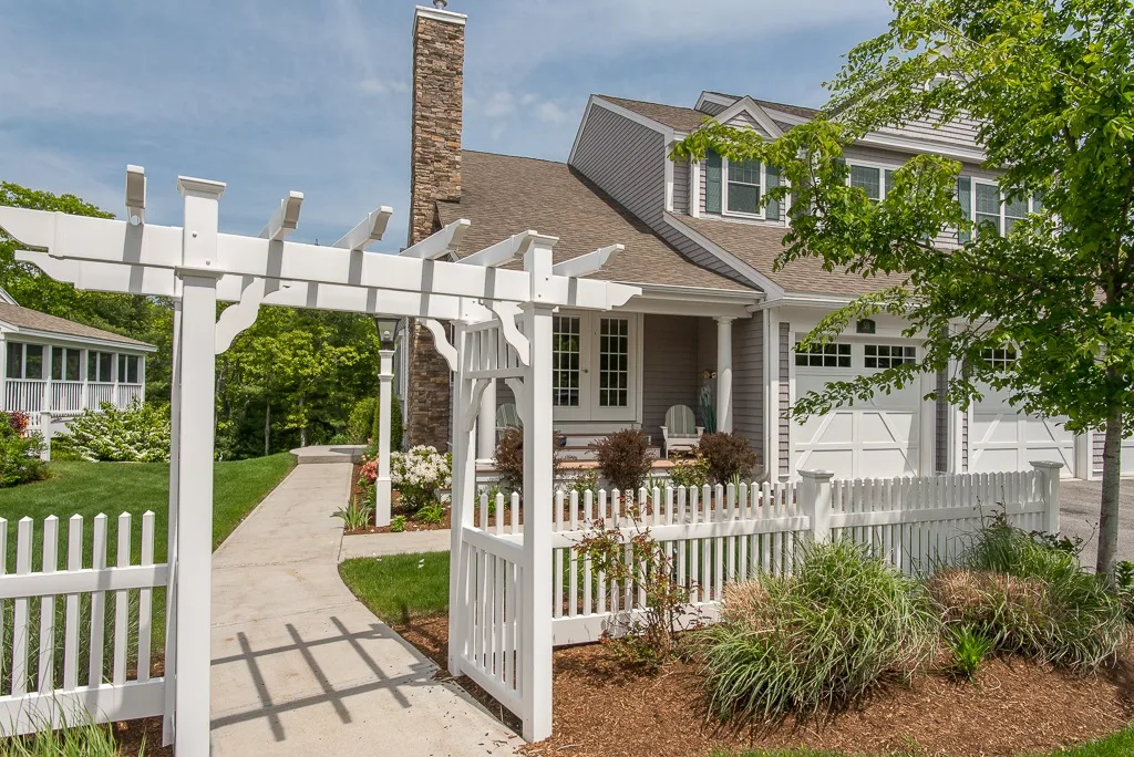 The front exterior of the home at 5B Plover Way in Gloucester, with a covered porch and white picket fence