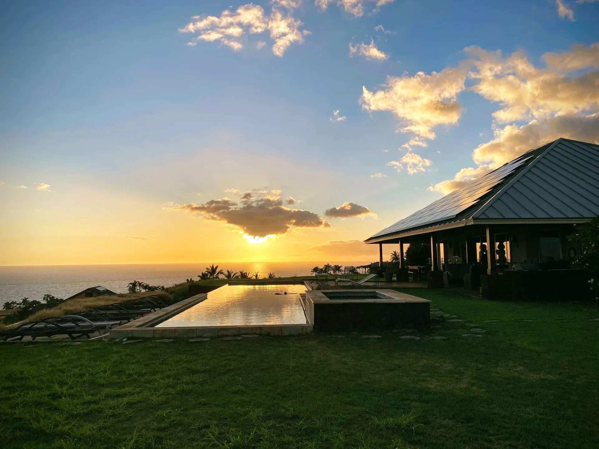 A single-family Kohala Coast home with an infinity pool and ocean view at sunset