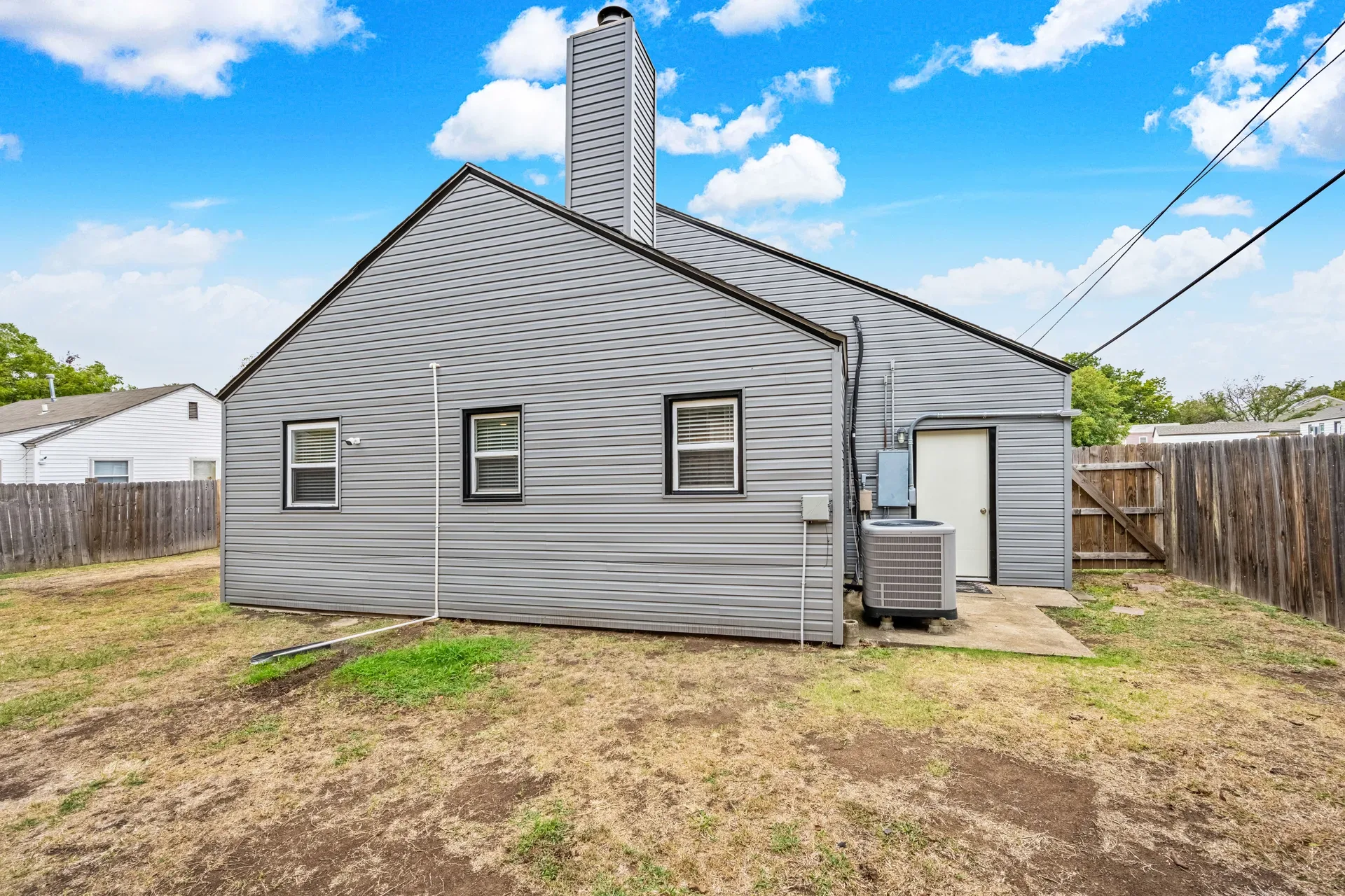 Backyard of 1211 NW Parkview Blvd with brick chimney and privacy fencing