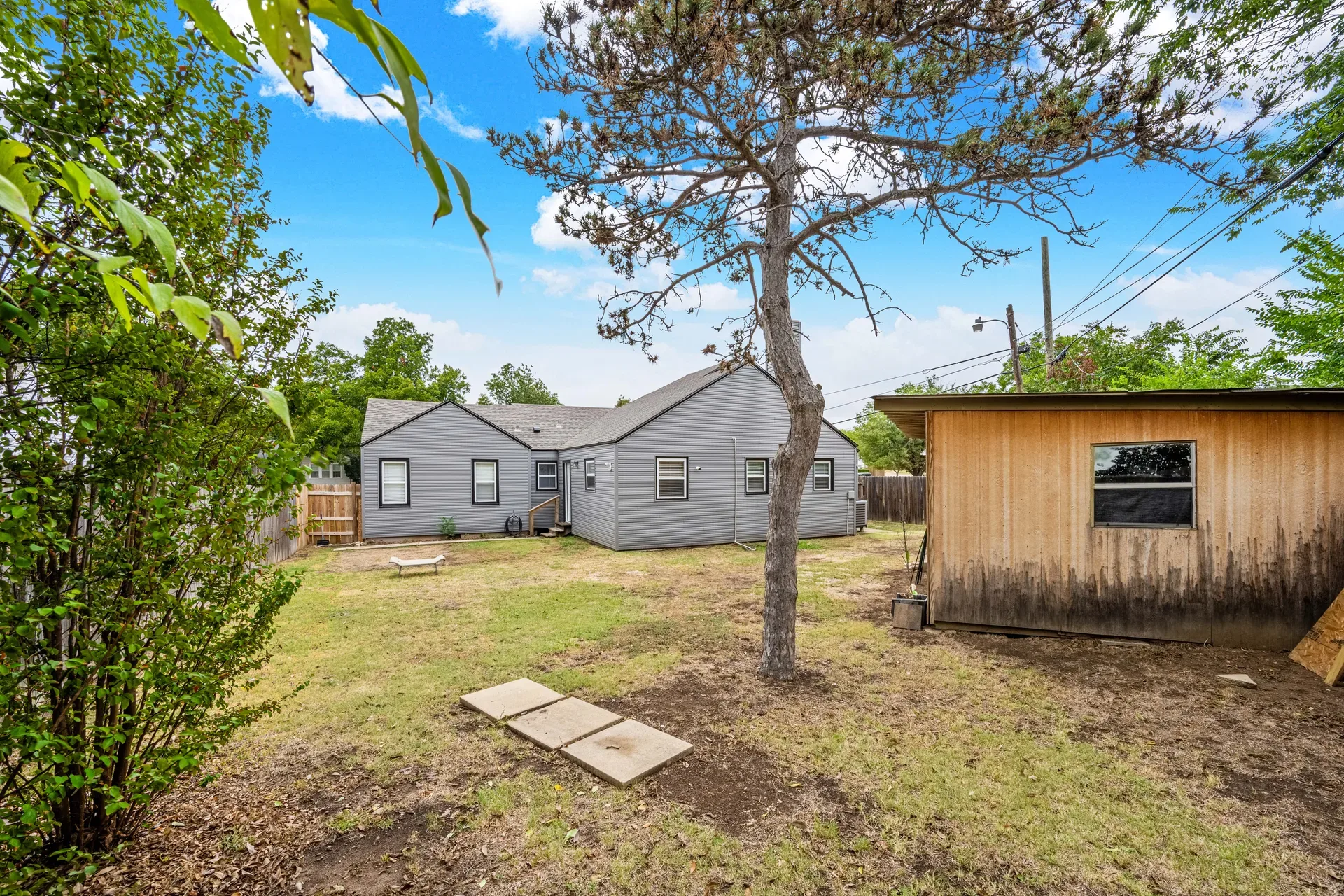 Backyard with mature tree and wooden storage shed