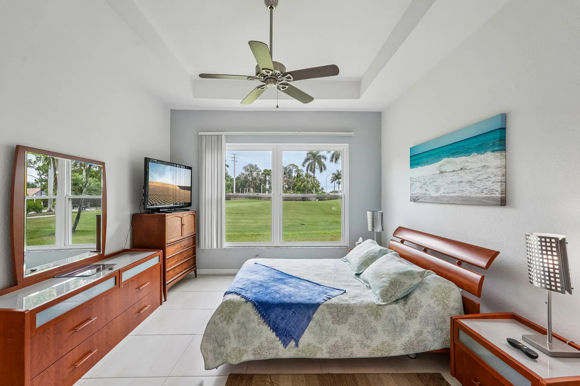 Primary bedroom with large windows overlooking the golf course