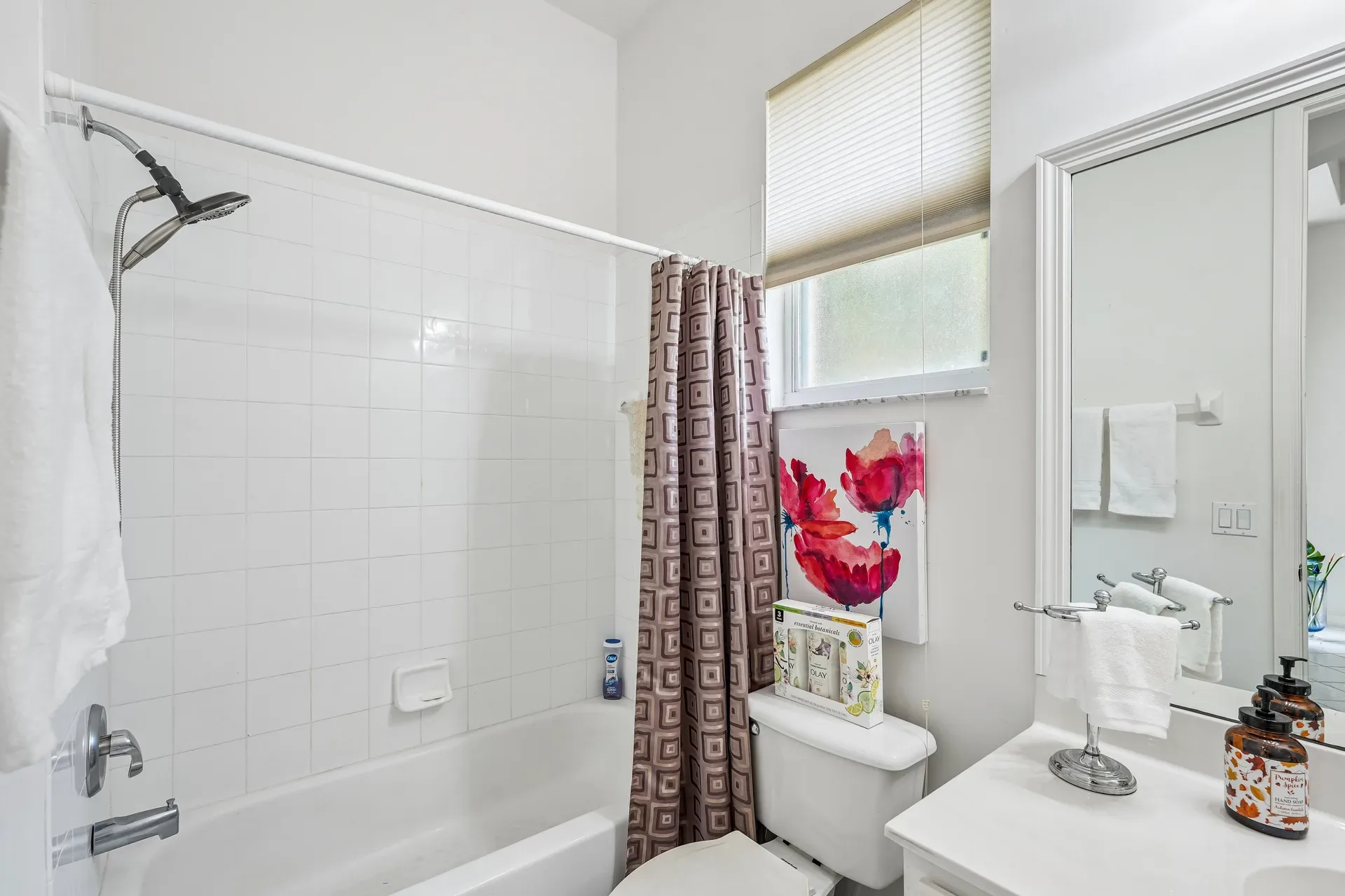 Bathroom with white tiled tub surround and white vanity cabinetry