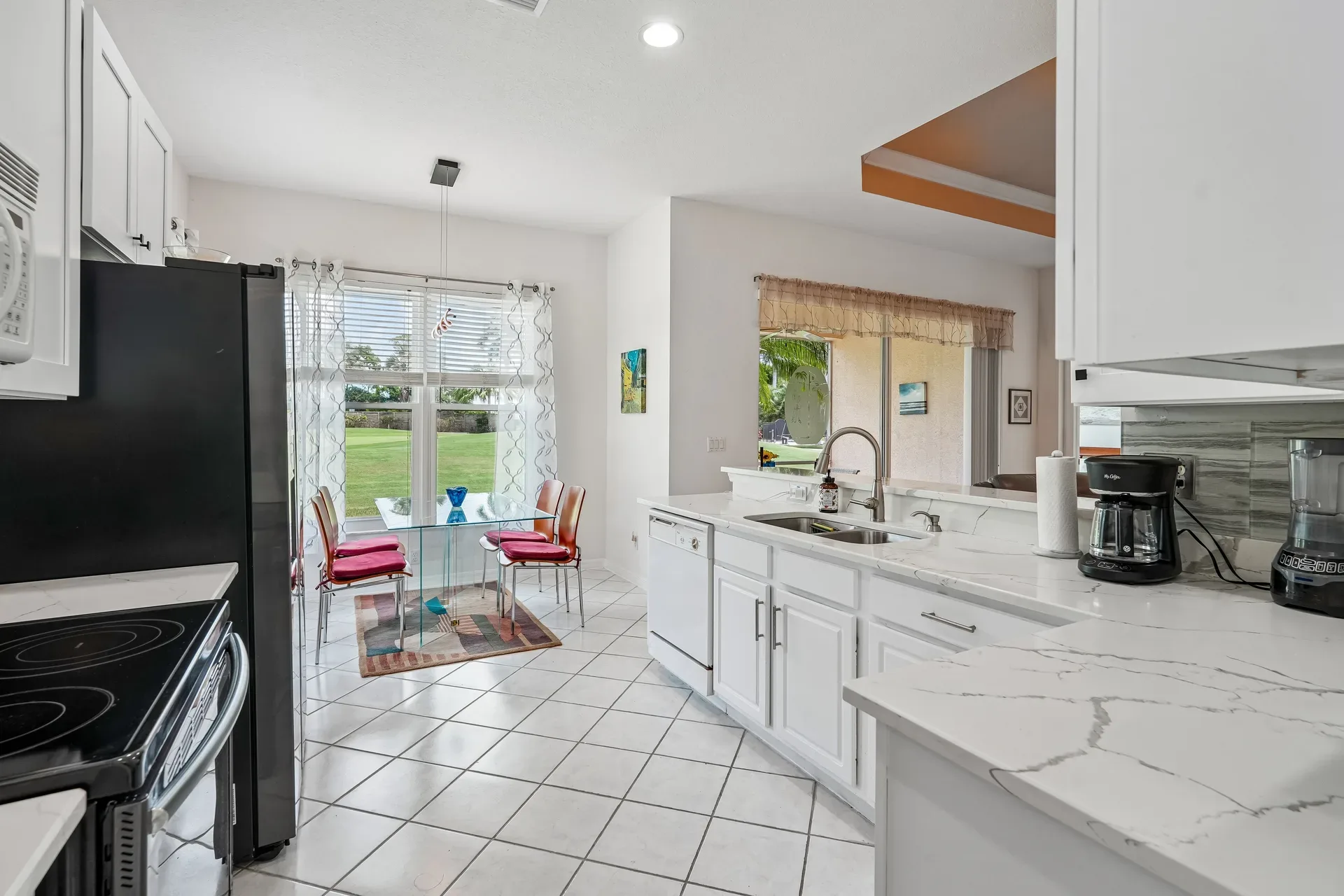 Updated kitchen and dining area with quartz countertops and windows overlooking the golf course