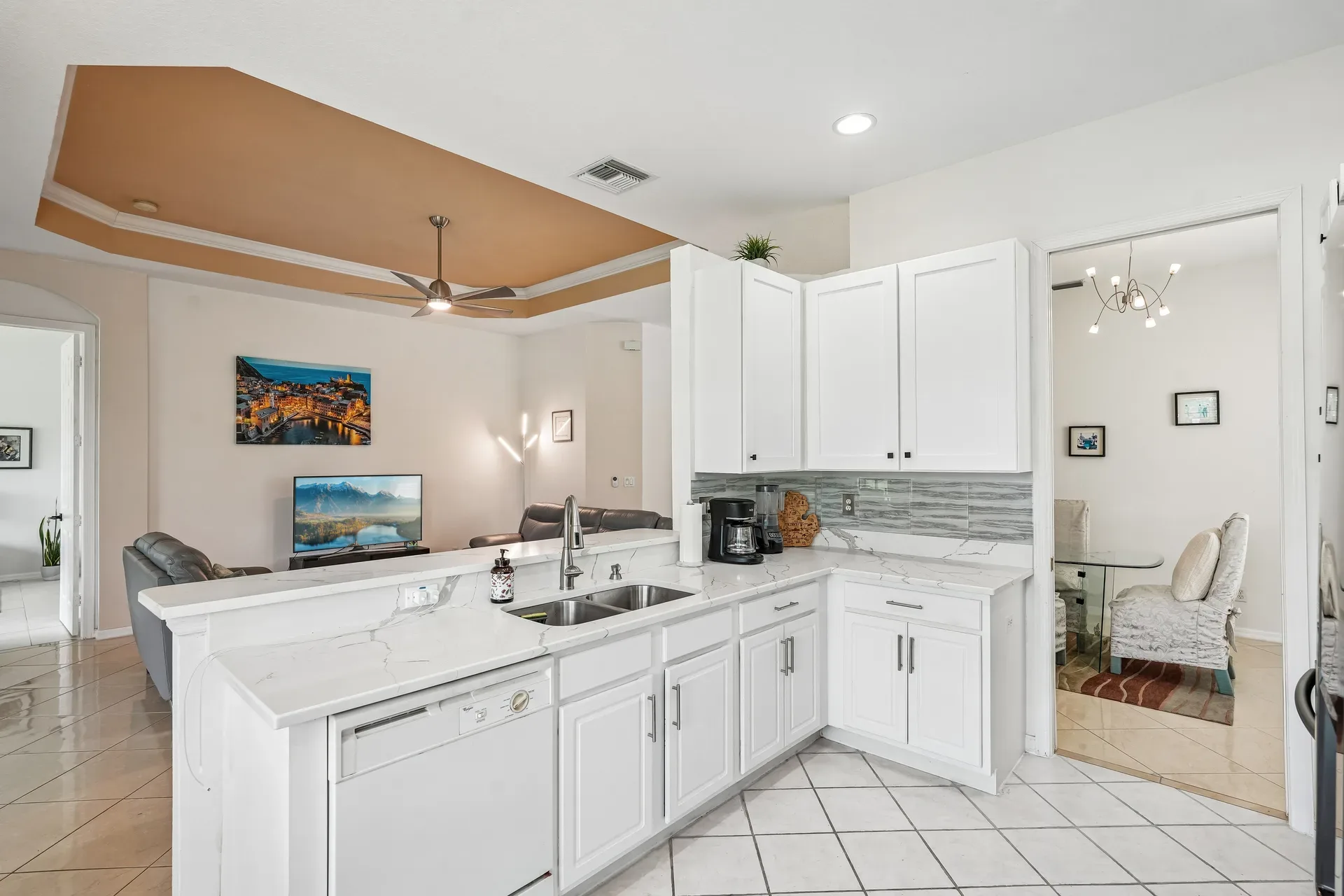 Updated kitchen with quartz counters looking into the living and dining areas