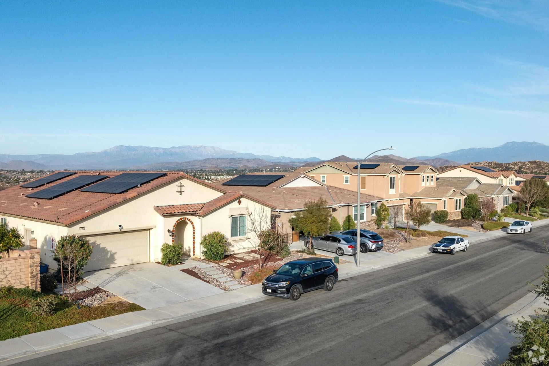 An aerial view of a residential neighborhood with stucco homes and tile roofs in Quail Valley, Menifee