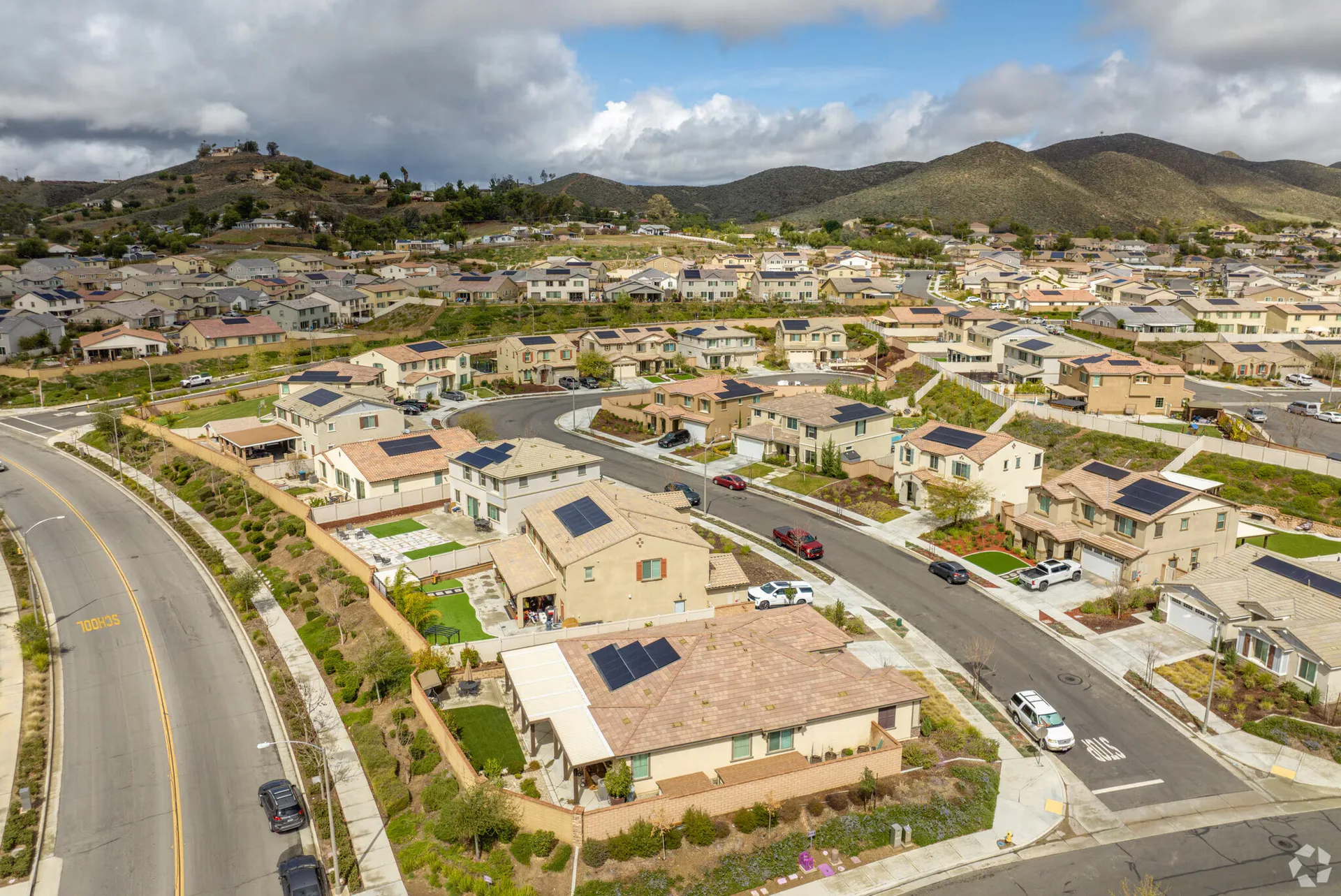 A high-angle aerial view of the Audie Murphy Ranch neighborhood with stucco homes, tile roofs and solar panels on tree-lined streets