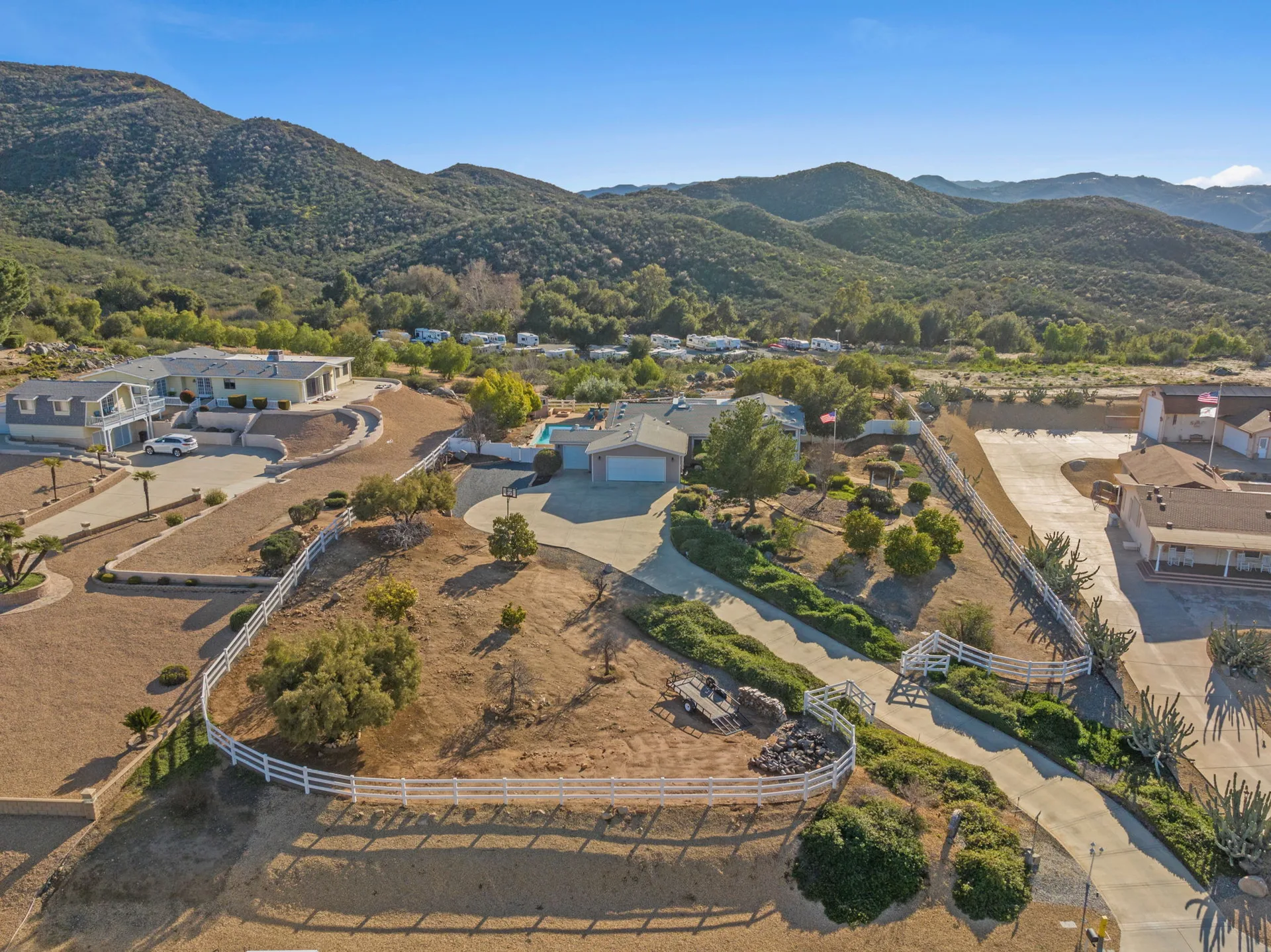 A rural property with white fencing and rolling hills in The Farm community in Wildomar