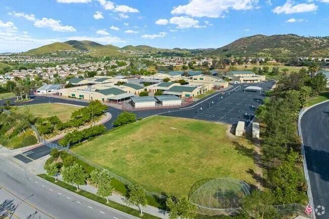 Aerial view of a school campus with green roofs, sports courts and grass fields in the Canyon Hills area
