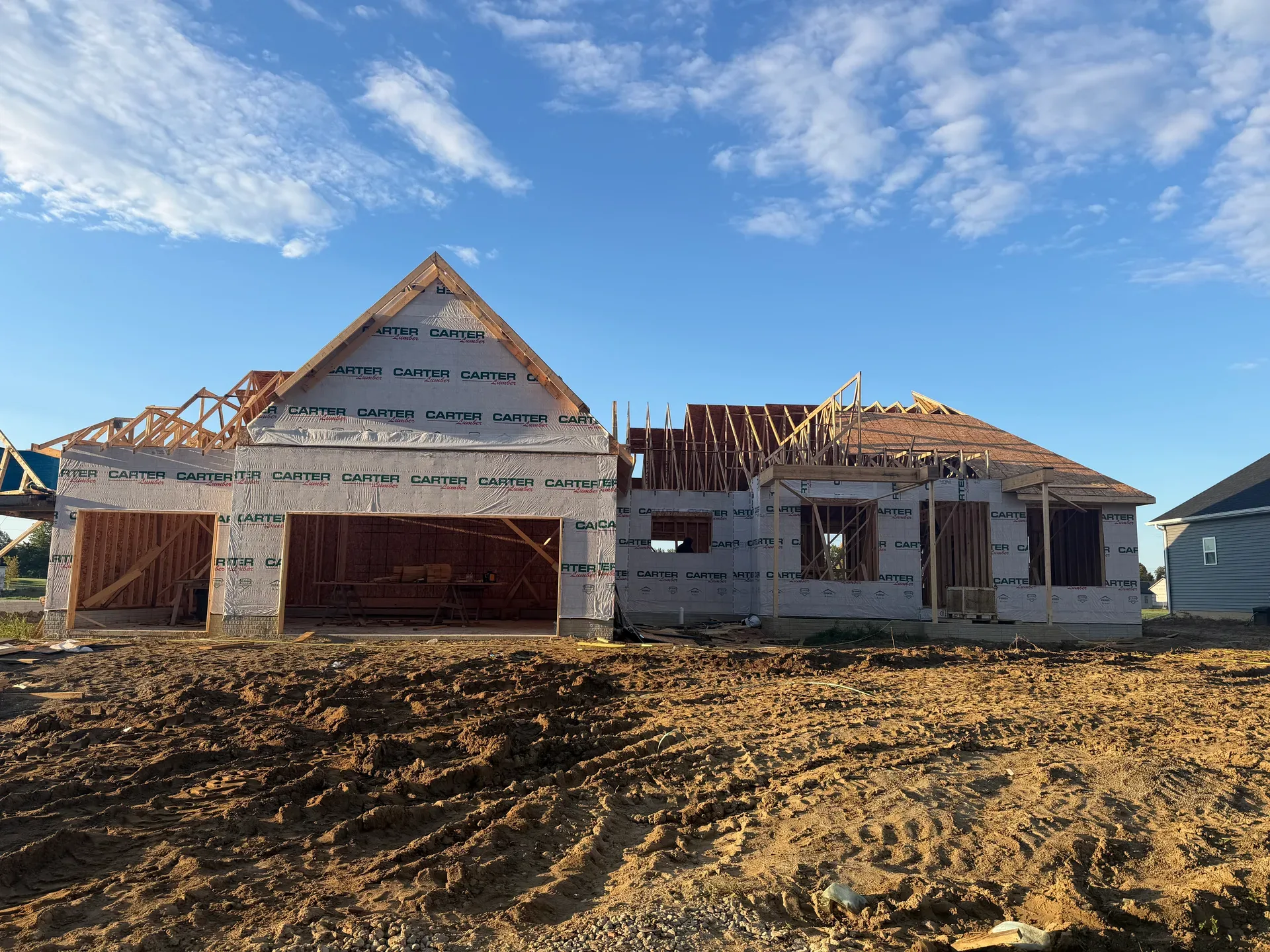 Framing phase with house wrap and exposed roof trusses