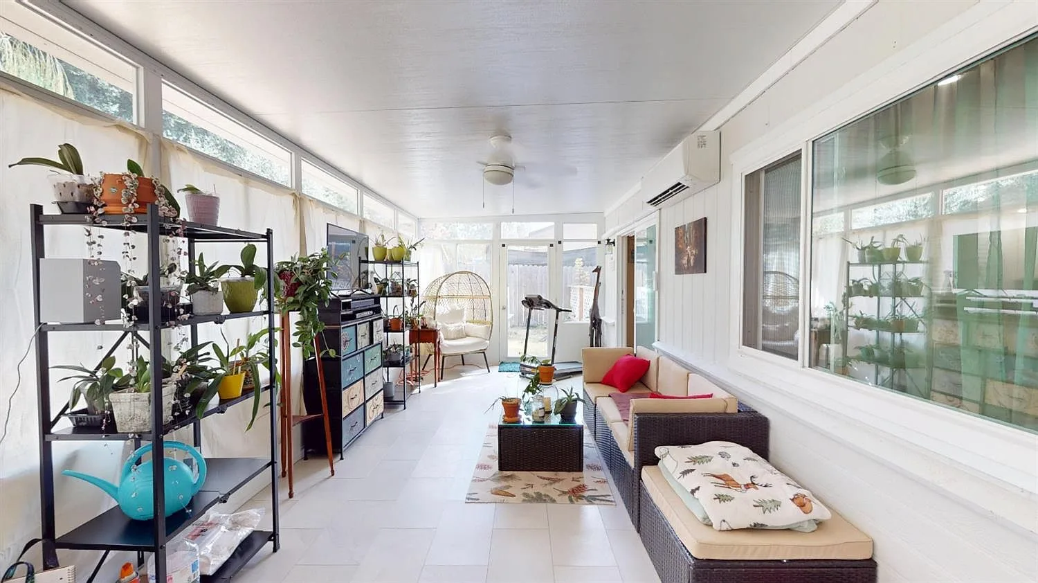 The custom-built sunroom at 4589 Volo Mine Dr, with white walls, large windows, and tile flooring