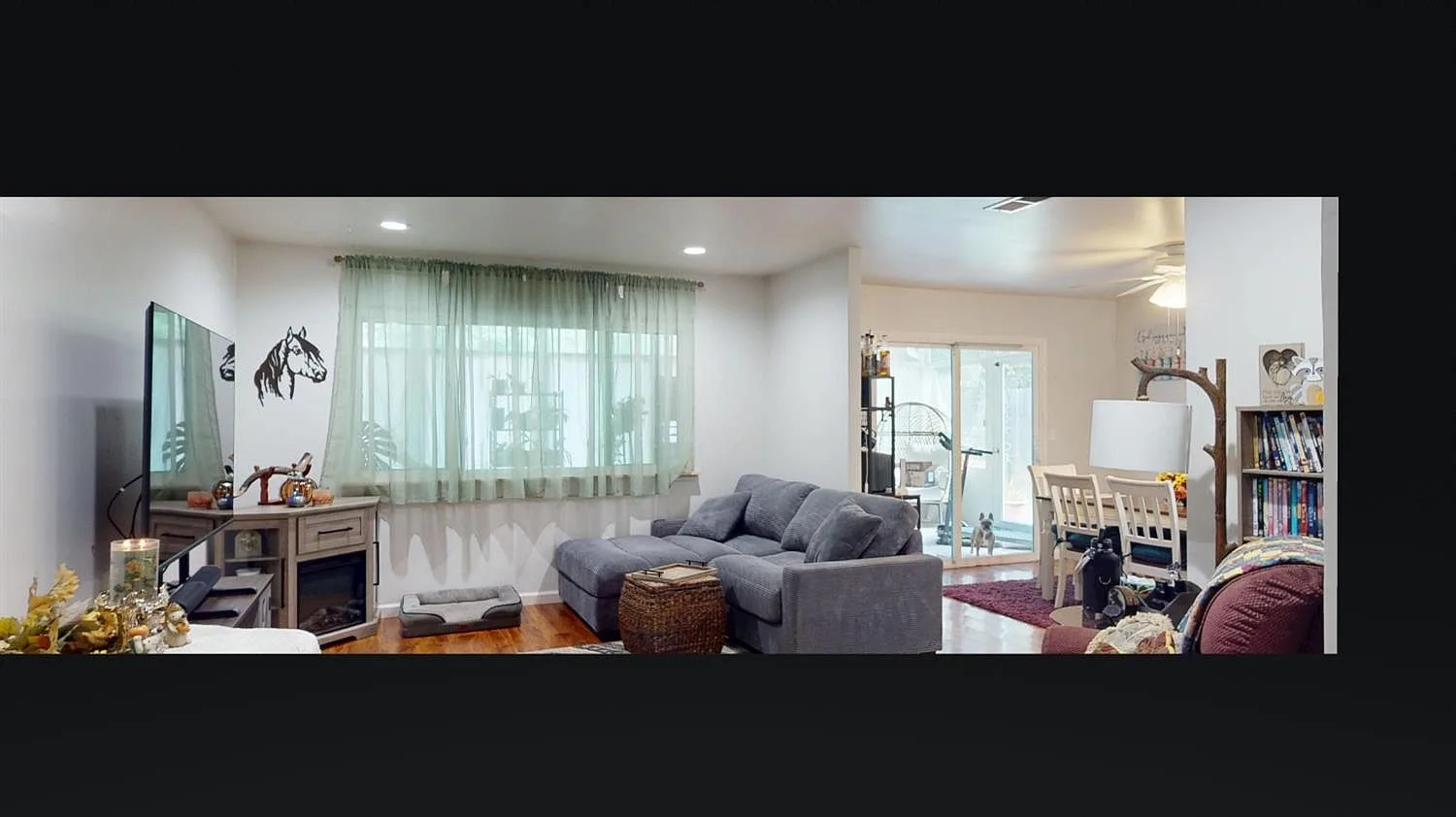 Open living and dining area with wood-look laminate flooring