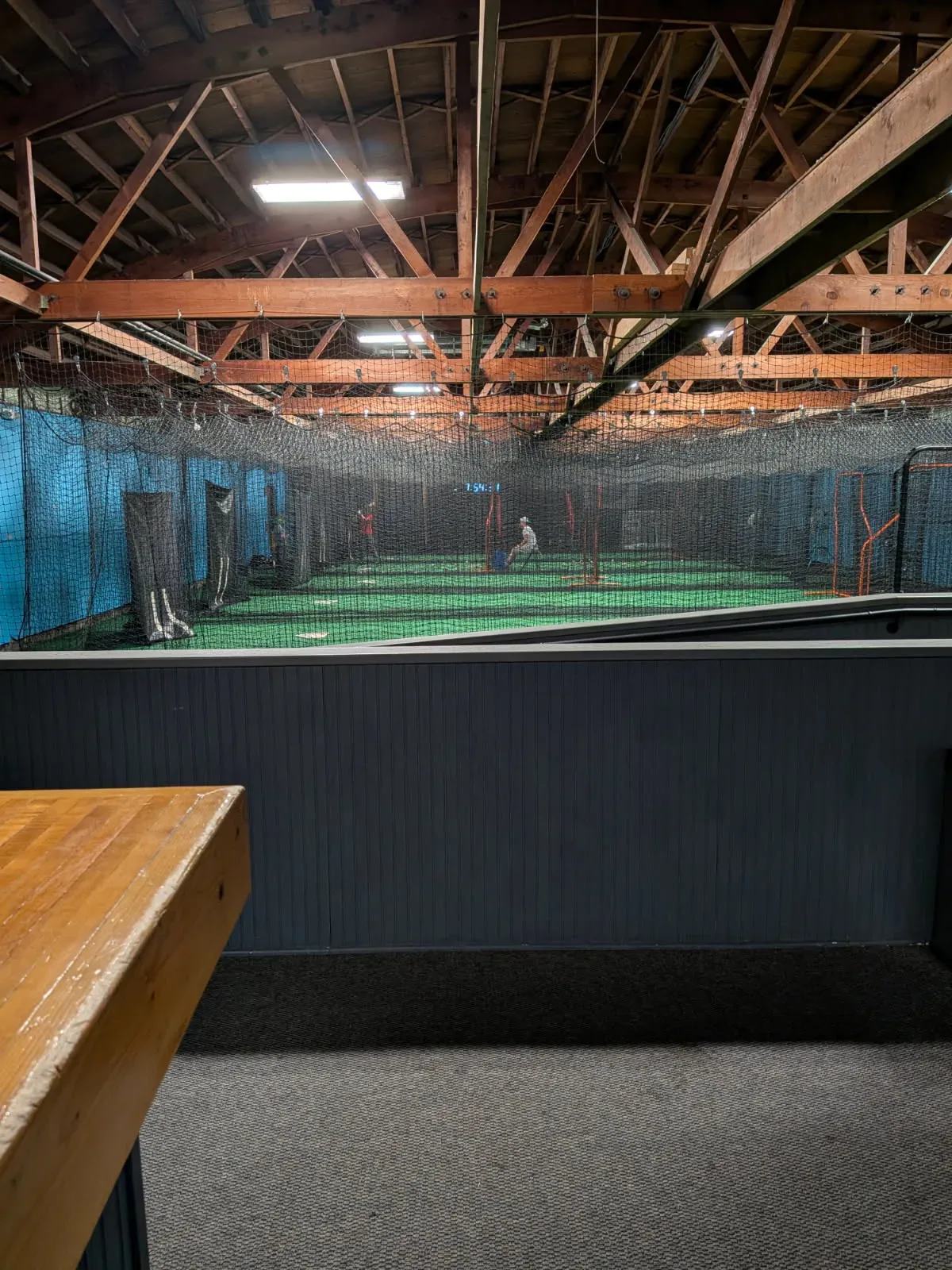 Bright, clean indoor batting cages with turf floors and a pitching machine at Batter's Alley in Palmyra, New Jersey