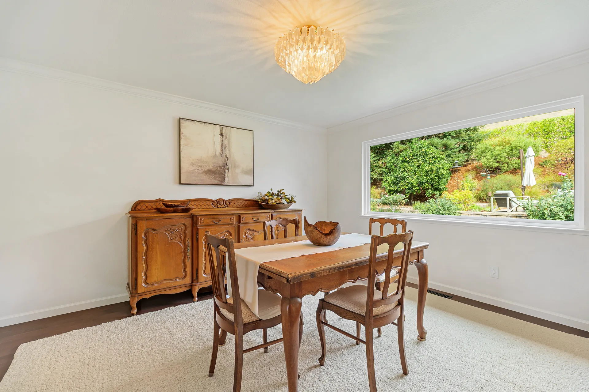 Dining room with a large horizontal window looking out to the backyard