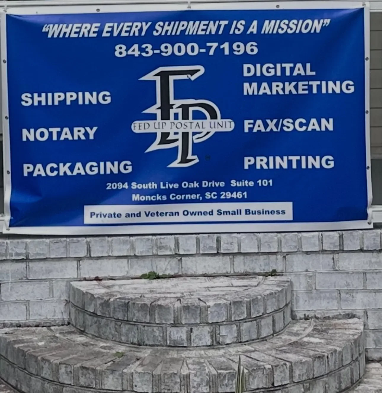 The blue Fed Up Postal Unit storefront sign in Moncks Corner, listing shipping services, phone (843) 900-7196, and the Moncks Corner address