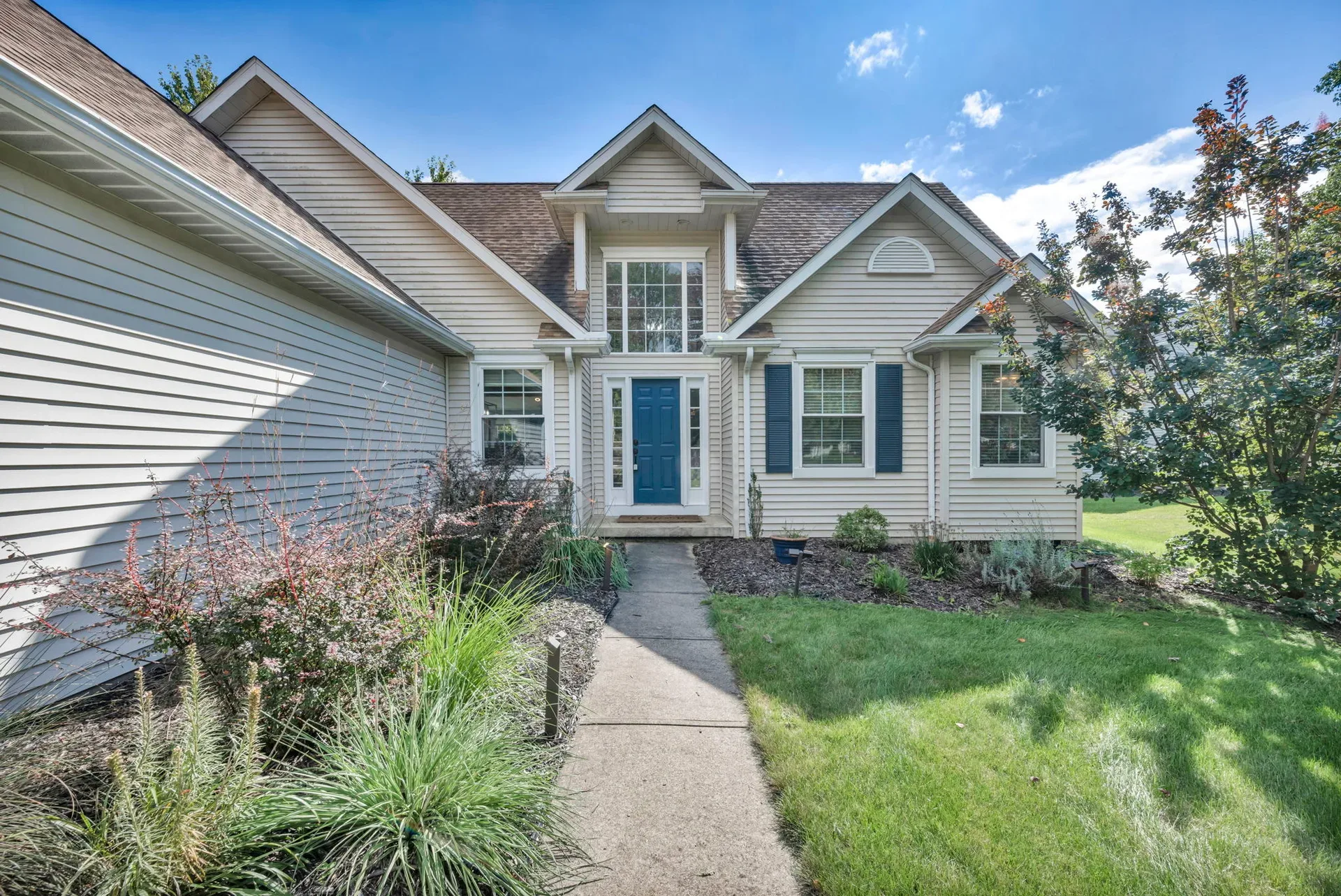 Front exterior of 188 W Sturbridge Dr with blue shutters and landscaped yard