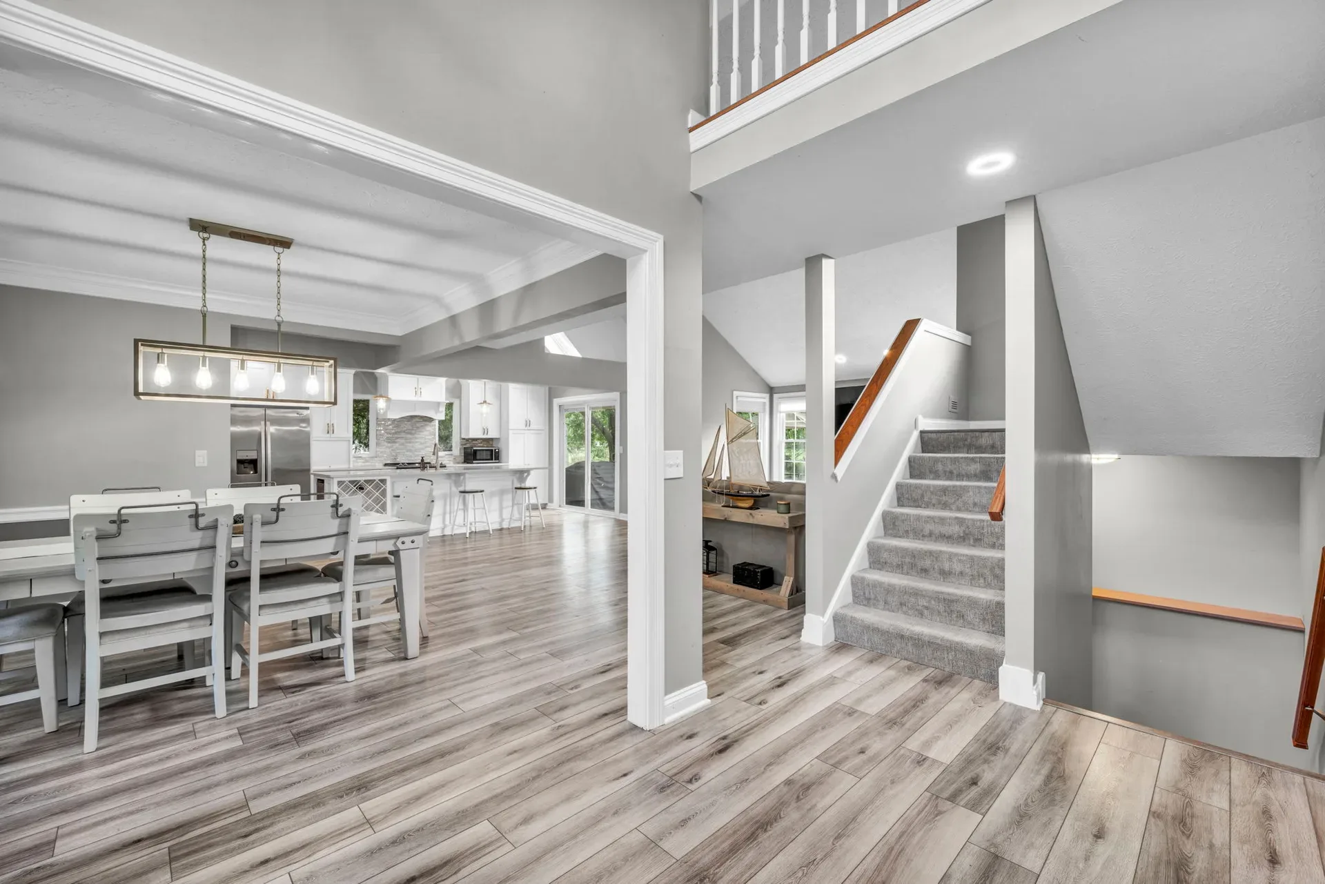 Open living and dining area with a staircase and wood-look flooring