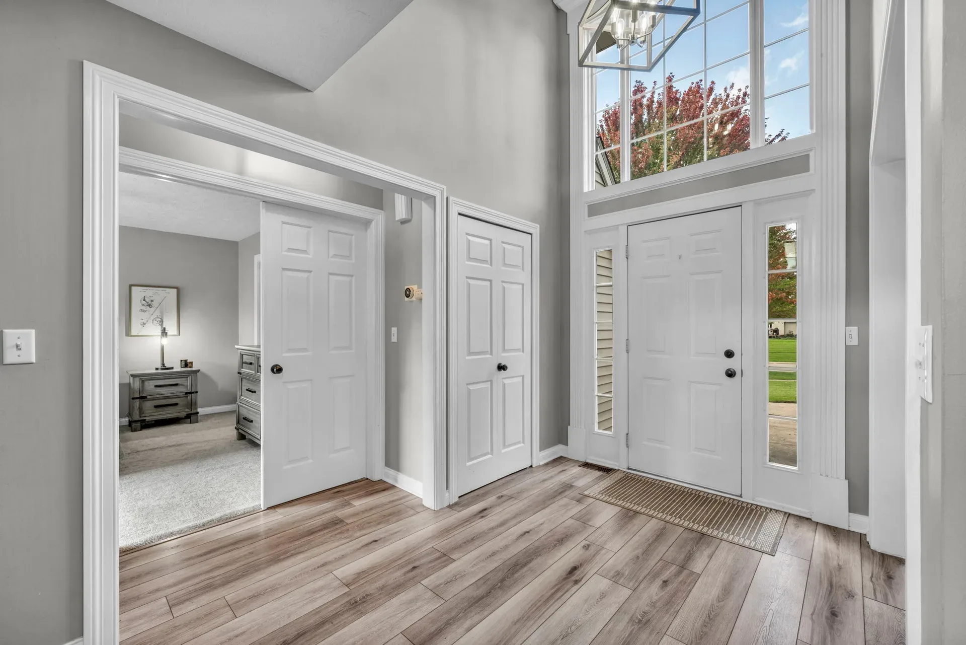Two-story foyer entryway with wood-look flooring and natural light