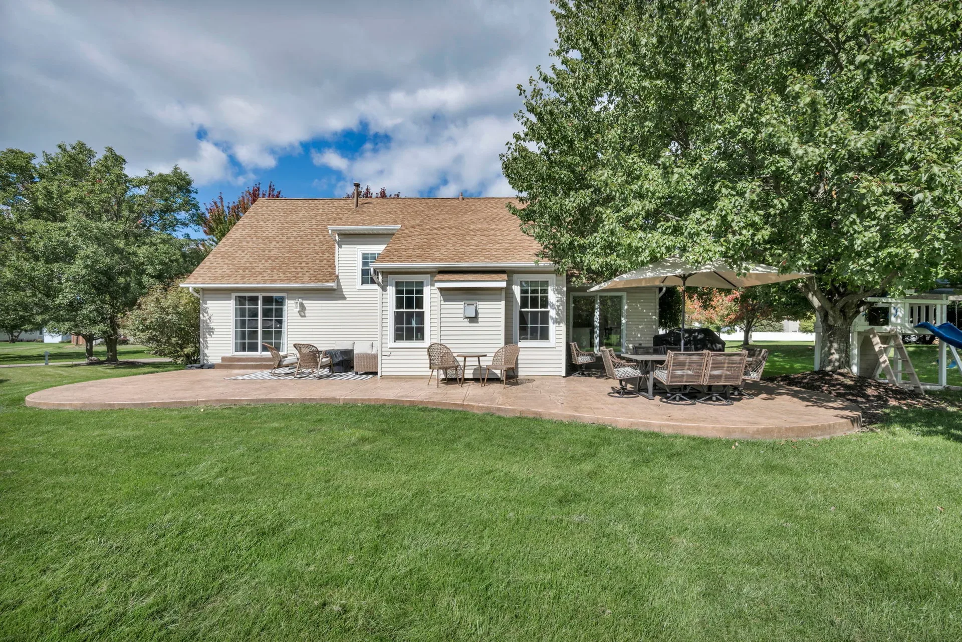 Backyard patio with stamped concrete and a fenced lawn