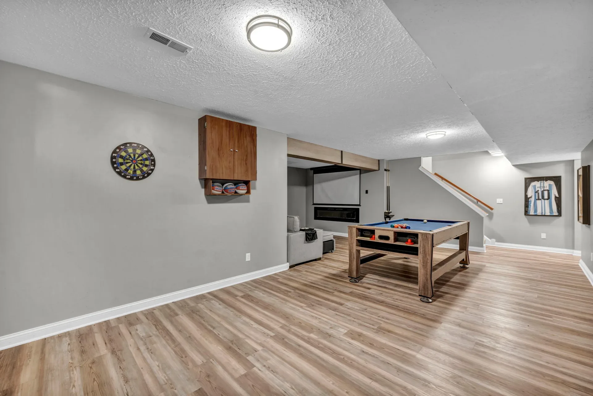 Finished lower-level game room with a pool table and sectional seating