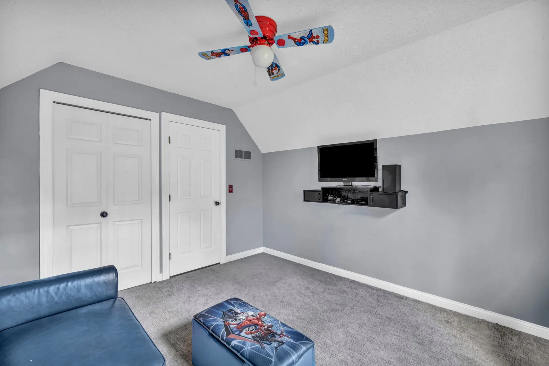 Secondary bedroom with a sloped ceiling and gray carpet
