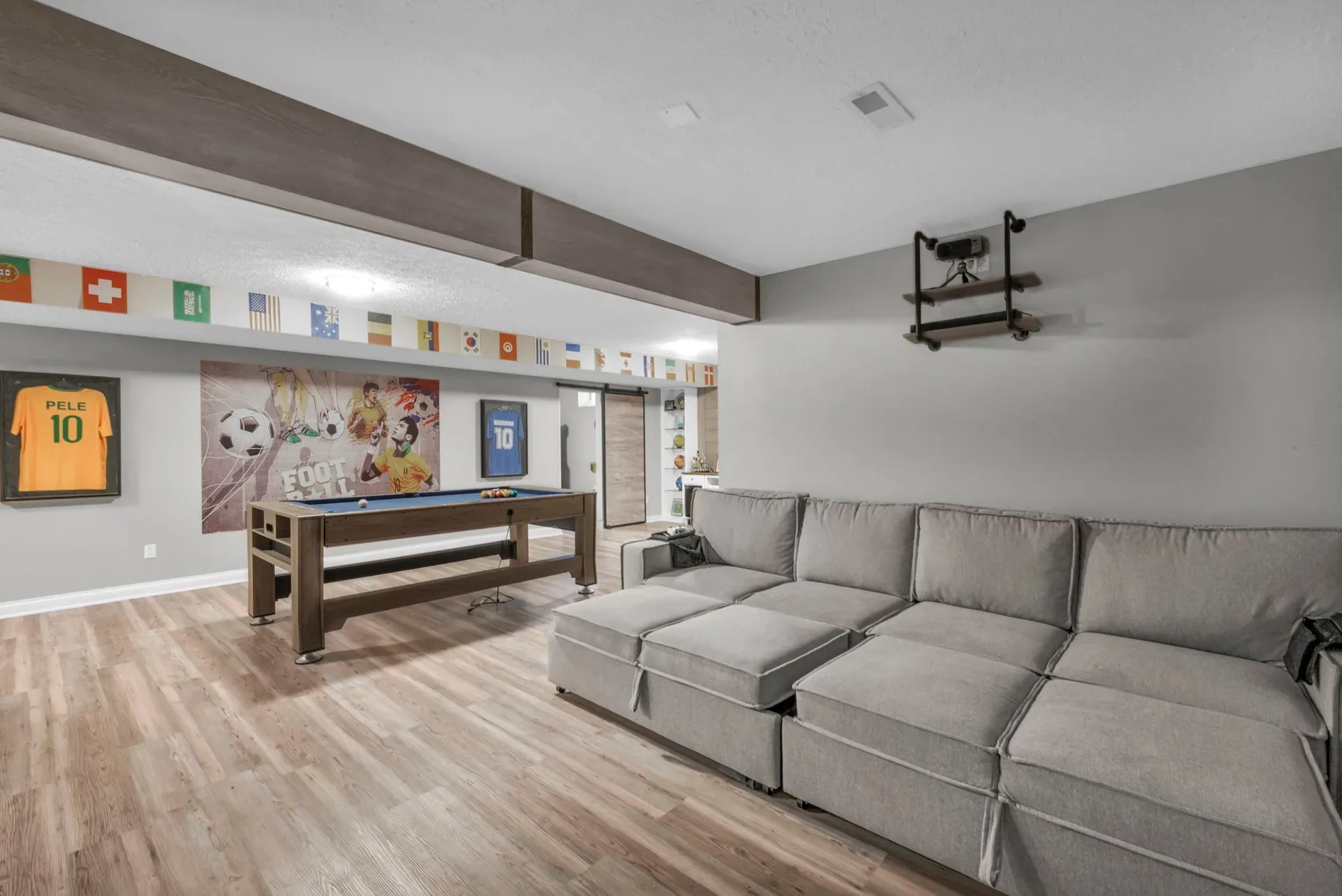 Basement recreation room with a sectional sofa and pool table