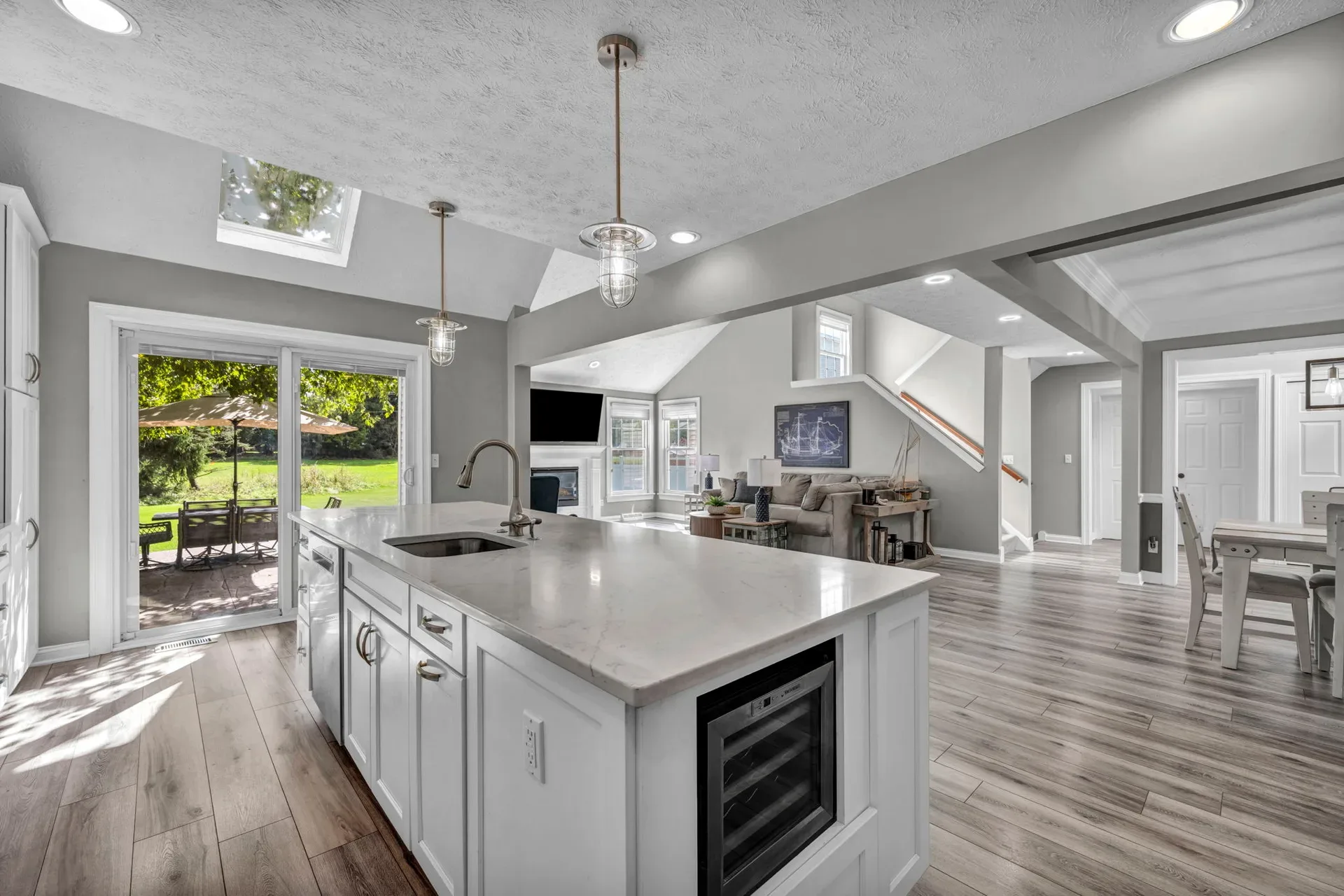 Kitchen island open to the living area with white cabinetry and a skylight