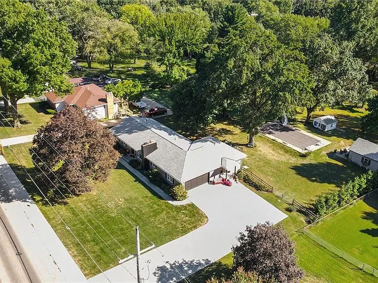 Aerial view of 10035 W 55th Street showing the home and its 1.42-acre lot with mature trees