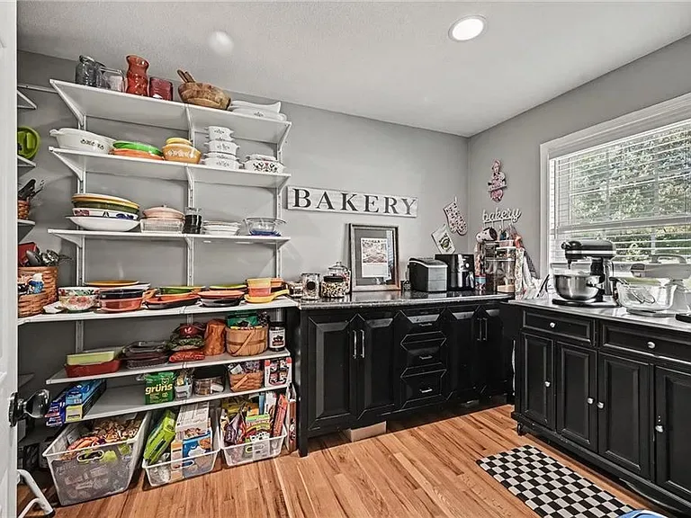 Large pantry with custom cabinetry and open shelving off the kitchen at 10035 W 55th Street