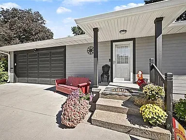 Front entryway of the renovated ranch home at 10035 W 55th Street in Merriam, Kansas, with a covered porch and attached garage