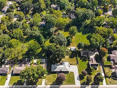 Aerial view of the Merriam property showing the long driveway, large backyard, and surrounding neighborhood