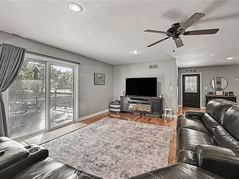 Family room with a fireplace and sliding glass doors at the Merriam home on 10035 W 55th Street
