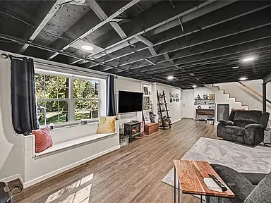 Finished walk-out lower level living area with wood-look flooring and recessed lighting at 10035 W 55th Street