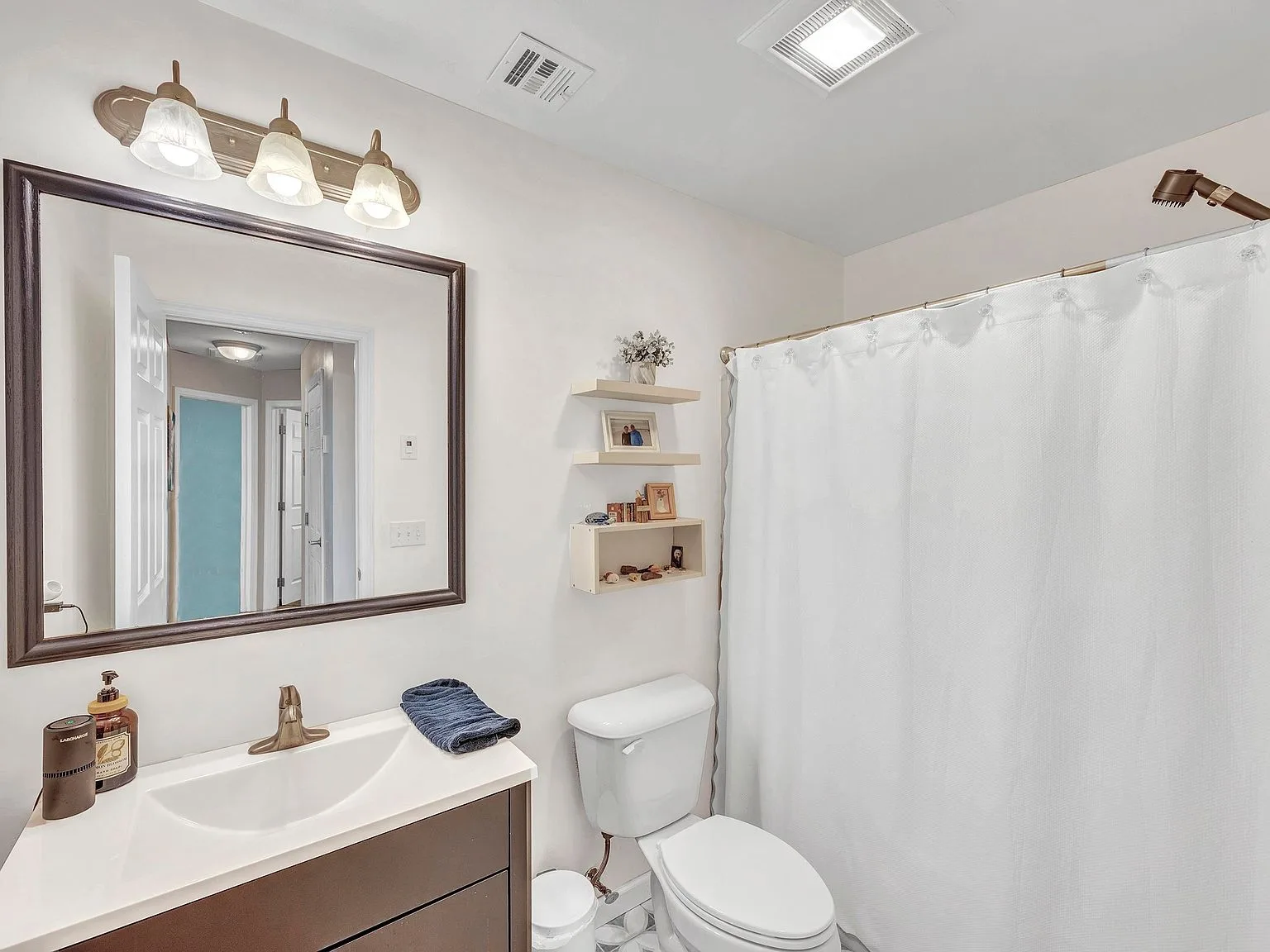 Full bathroom with dark vanity and mirror