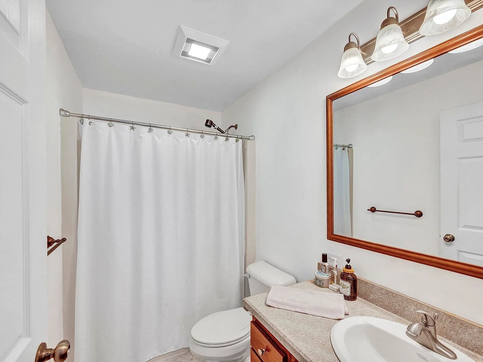 Full bathroom with wooden vanity and stone counter