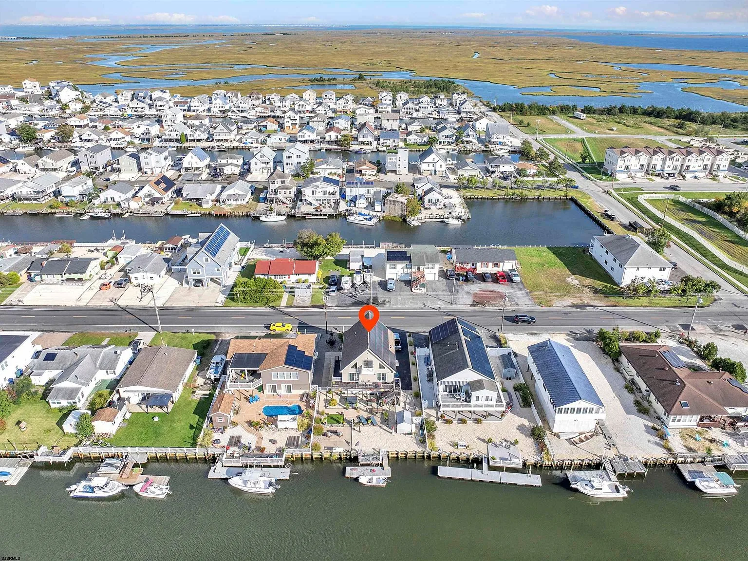 Aerial view of 1072 Radio Rd showing the fenced backyard, private dock, and lagoon