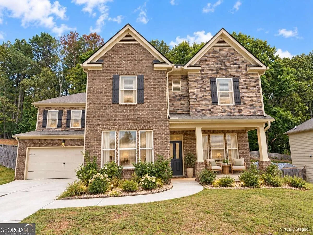 Front exterior of 2635 Ridge Manor Dr, a brick and stone home with dark shutters in Dacula, Georgia