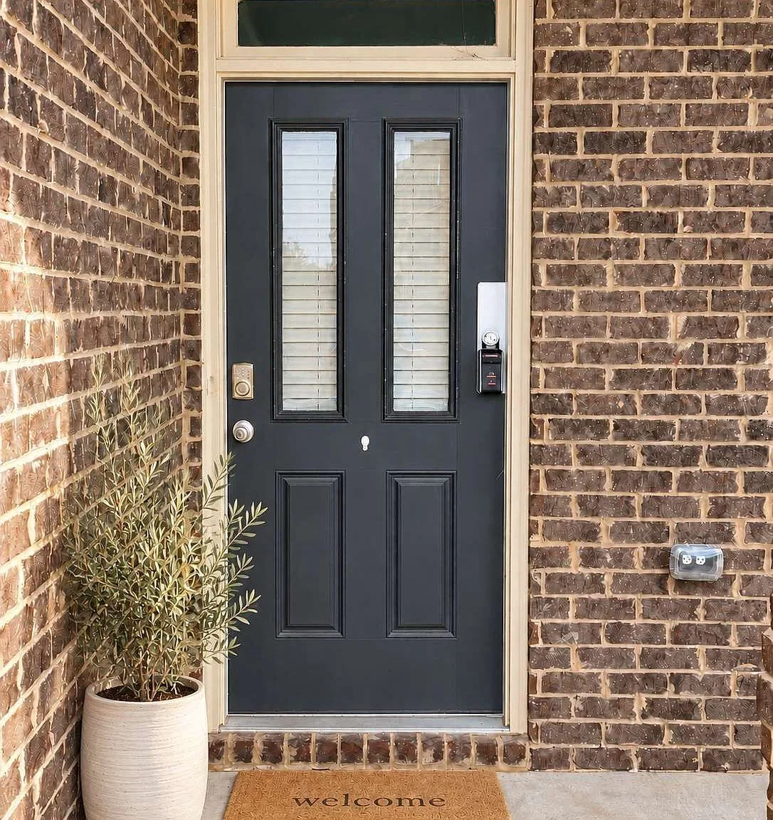 Front entry of 2635 Ridge Manor Dr with a dark grey painted door and glass sidelights