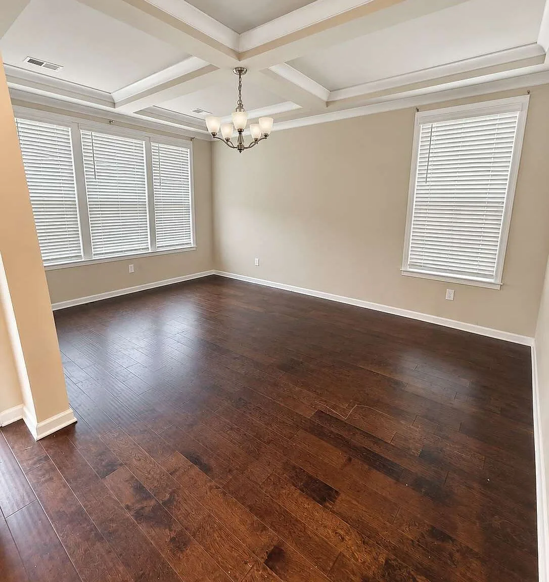 Coffered ceiling dining room with dark hardwood flooring