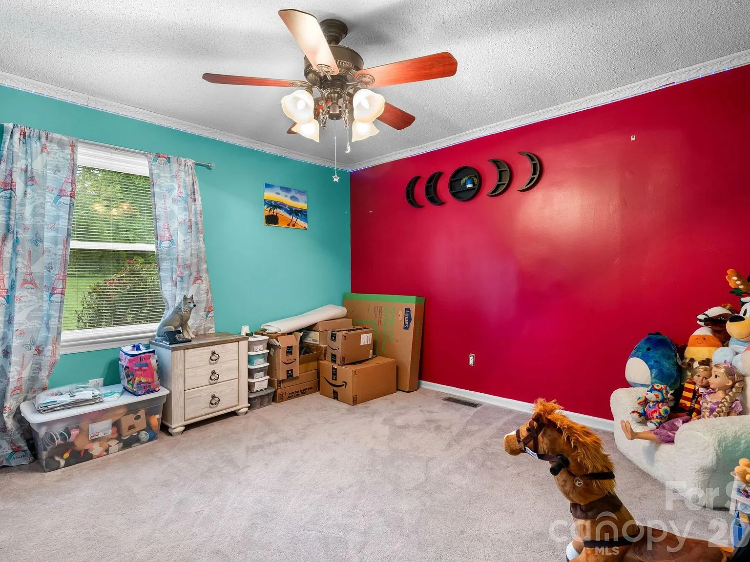Guest bedroom with colorful accent walls and natural light from a side window