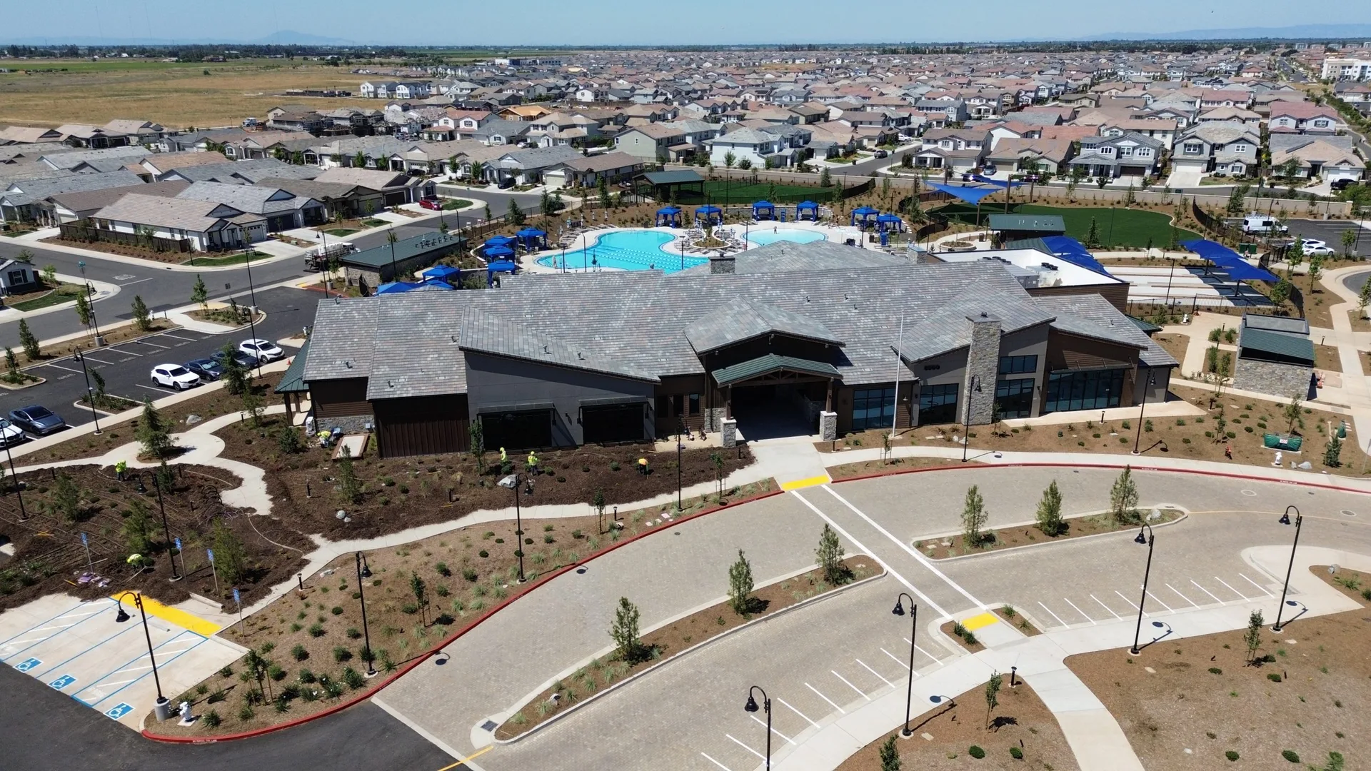 Drone aerial of the Lodge, pool, and surrounding homes at Esplanade at Madeira Ranch, the 55+ active-adult community in Elk Grove, California